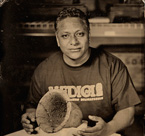 Mario Silva, a baker at the Medici Bakery on 57th Street is shown with an Egyptian bread pan from about 2630–2524 BC. OIM E1986