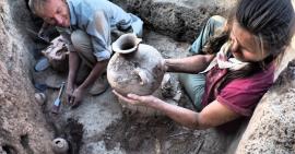 Image: Oriental Institute archaeologists work on an archaeological site to excavate a pot.
