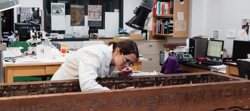 Fig. 3. Conservator Simona Cristanetti examining the coffin within the Oriental Institute's conservation laboratory. Photo Anna Ressman.